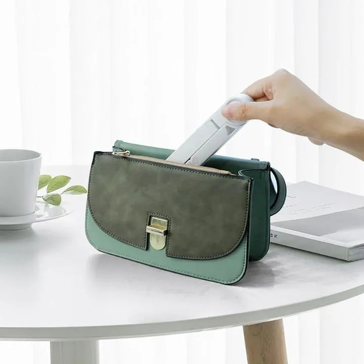 Black foldable tablet holder stand supporting a smartphone in landscape mode on a desk.