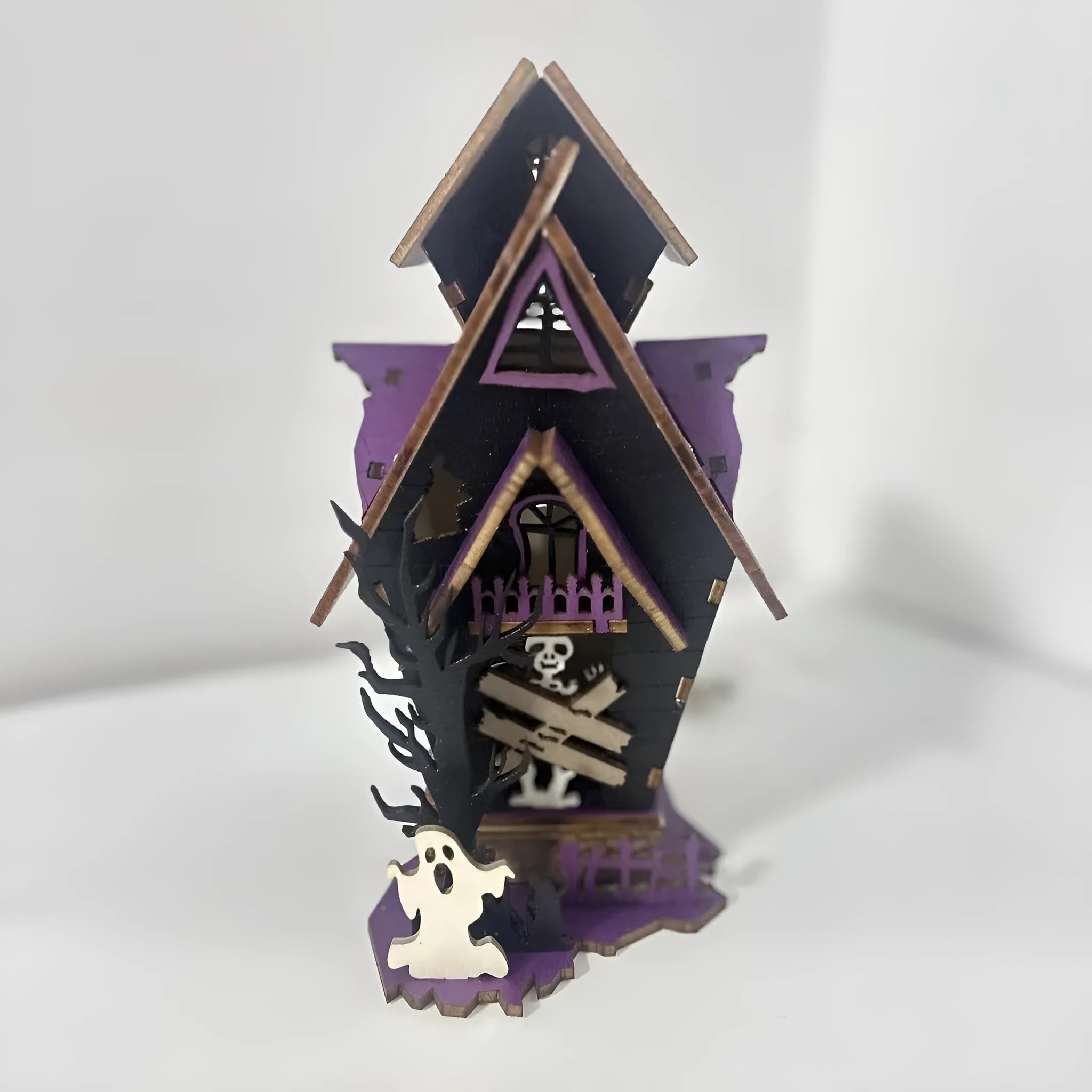 Unassembled DIY wooden haunted house Halloween decoration kit with glowing colour details.