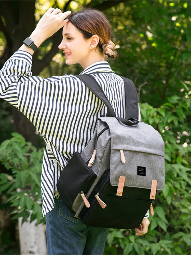 LAND Mommy large grey diaper backpack with multiple compartments and a changing mat laid out