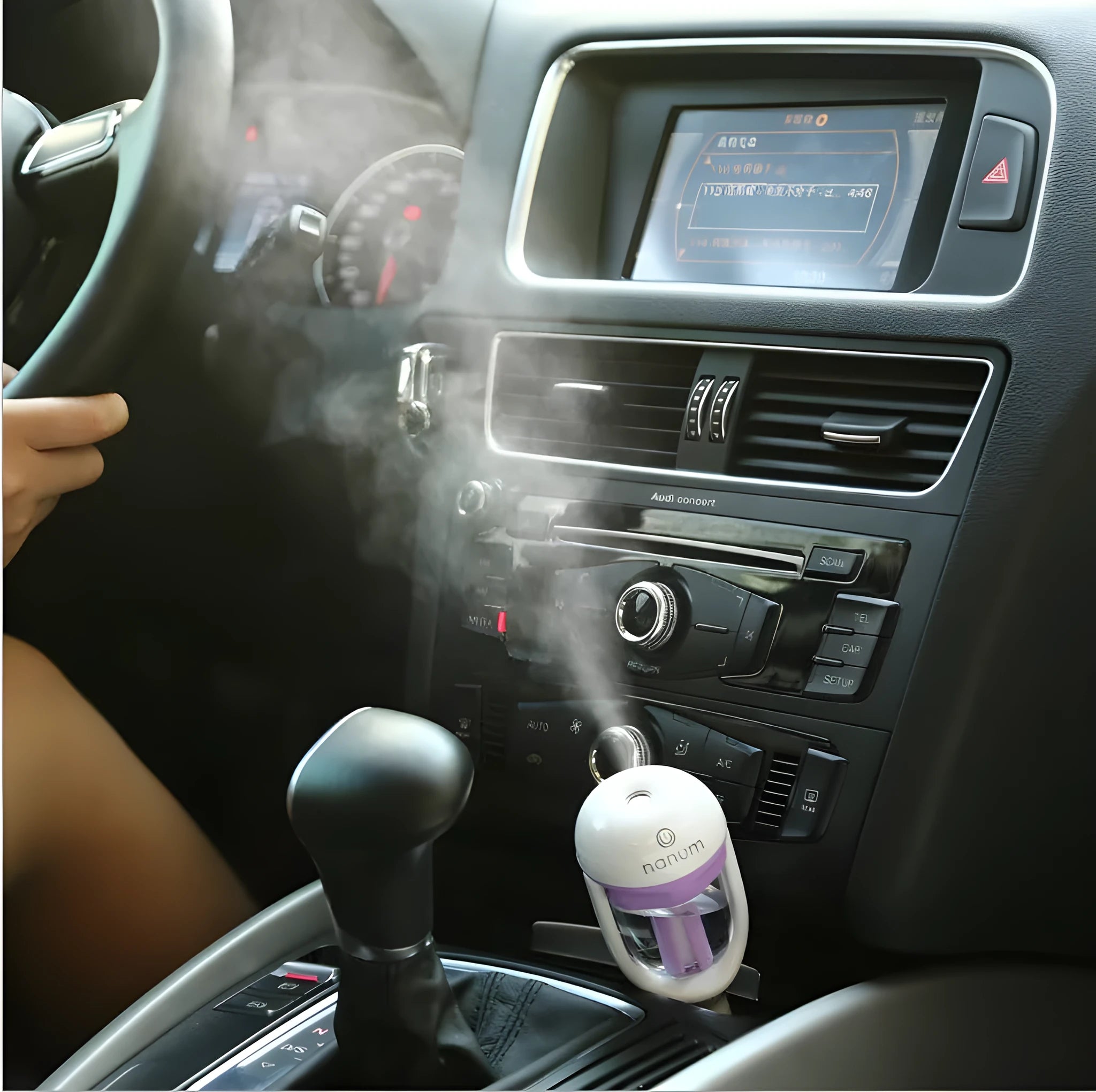 Compact blue portable car humidifier and air freshener diffuser on a car dashboard.