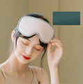 Pink and green portable USB steam sleep massage goggles on a table