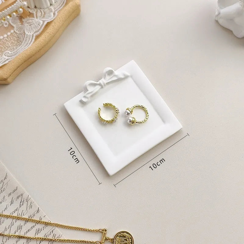 European Baroque style gypsum jewellery display plate with rings and earrings on a dressing table