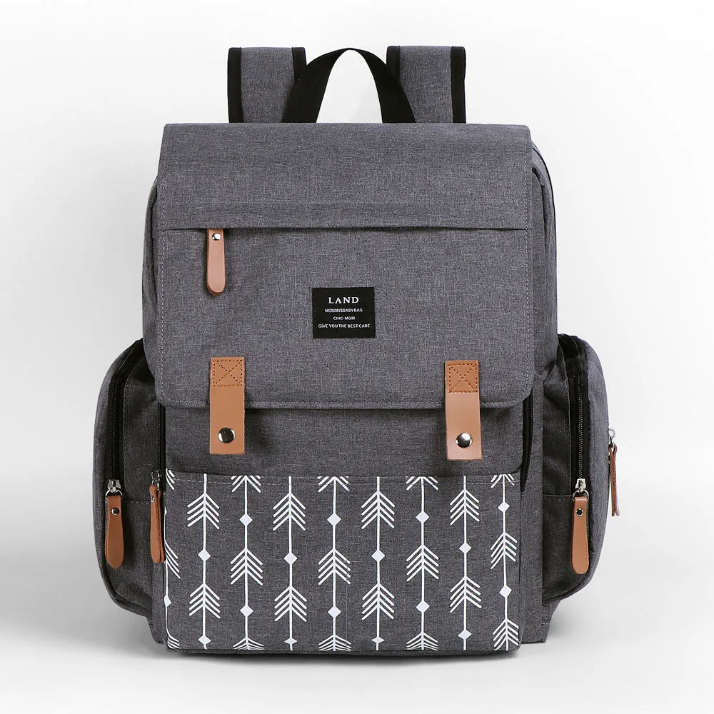LAND Mommy large grey diaper backpack with multiple compartments and a changing mat laid out