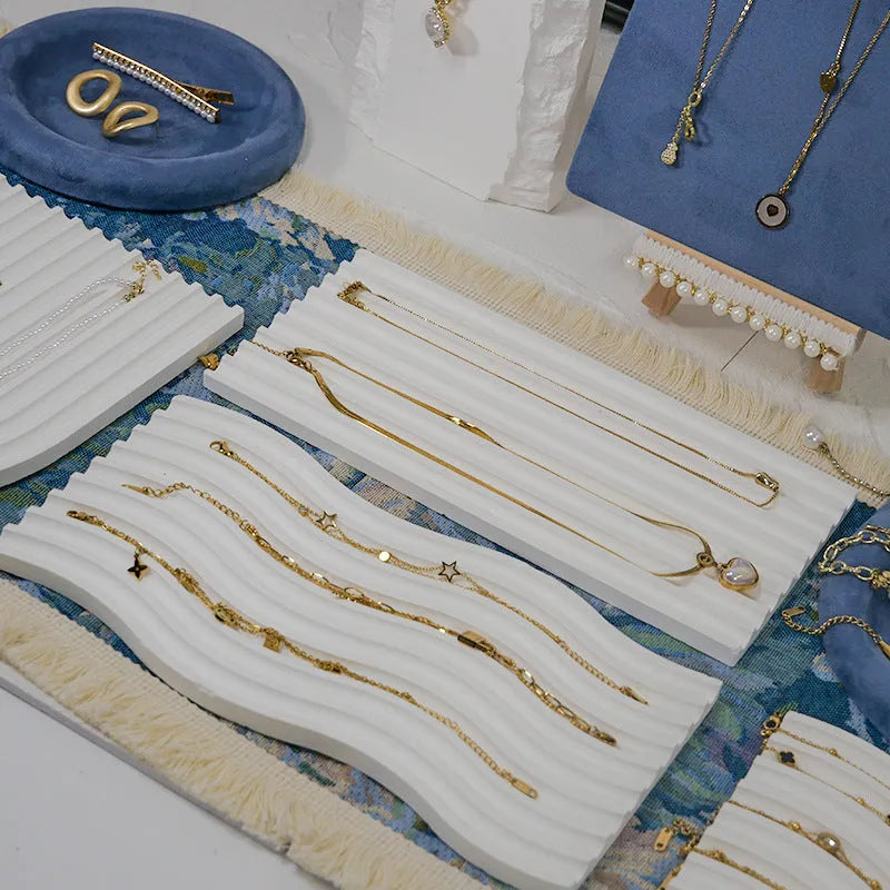 Handmade plaster jewellery display tray with necklaces and bracelets on a countertop