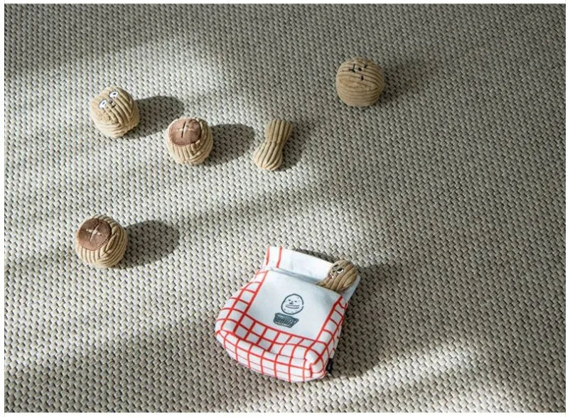 Hidden food toy set for dogs with two walnut toys, one peanut toy, and a rustling paper snack bag on a table