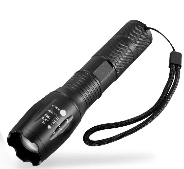 Black aluminum alloy zoom flashlight with adjustable head for focus, shown with beam reaching into distance.