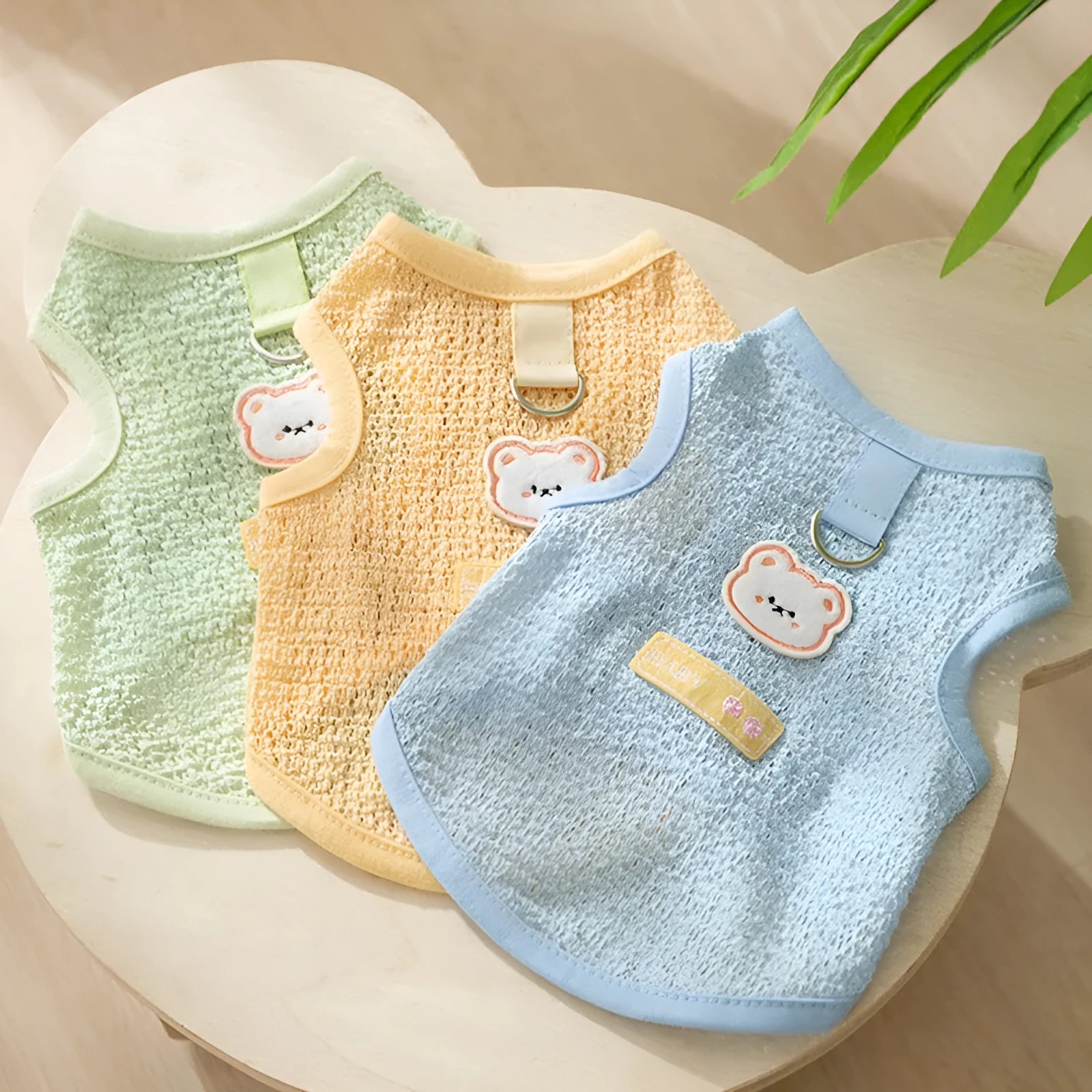 Hollowed-out cat clothes with bear patch in blue, green, yellow colours showing knitted fabric texture