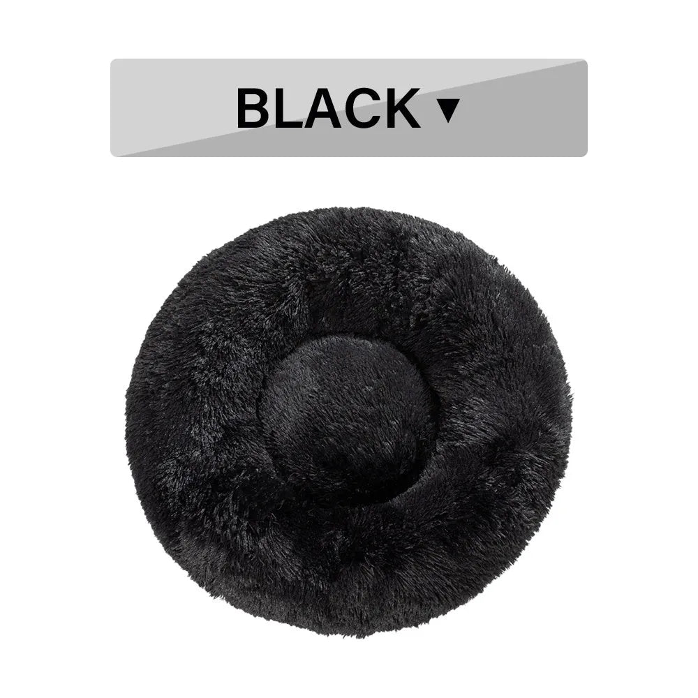 Fluffy donut-shaped dog bed in long plush material, shown in a light grey colour.