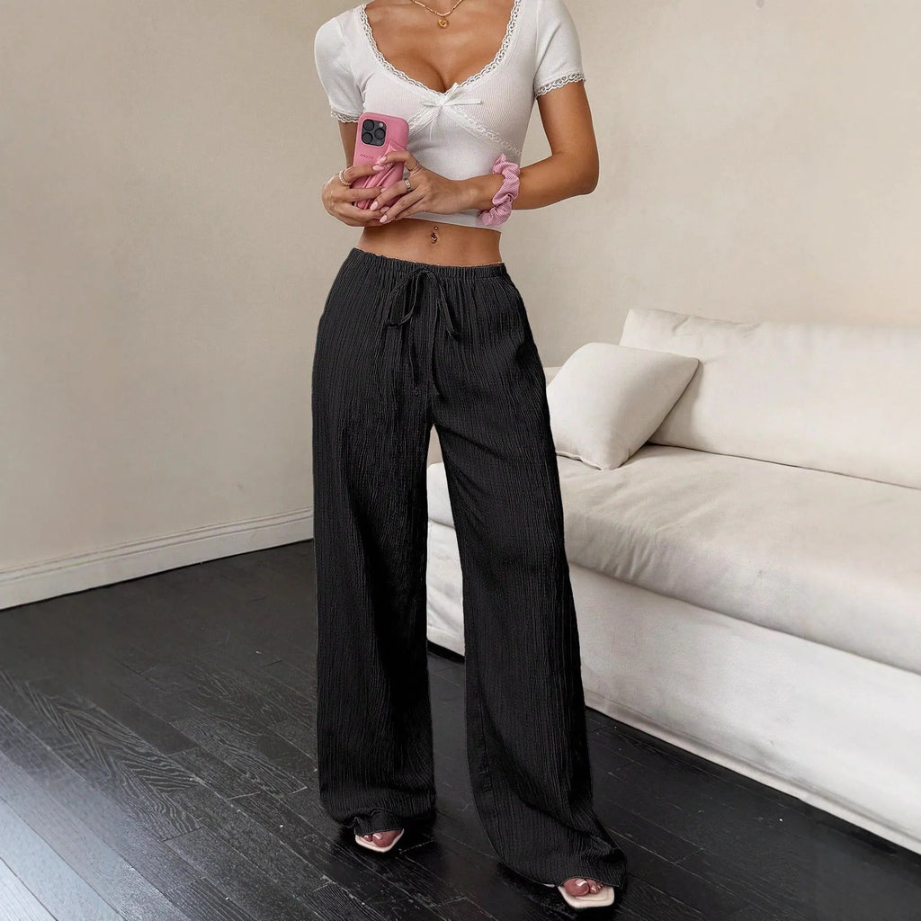 Women's black casual trousers with a lace-up waist detail and wide-leg silhouette.