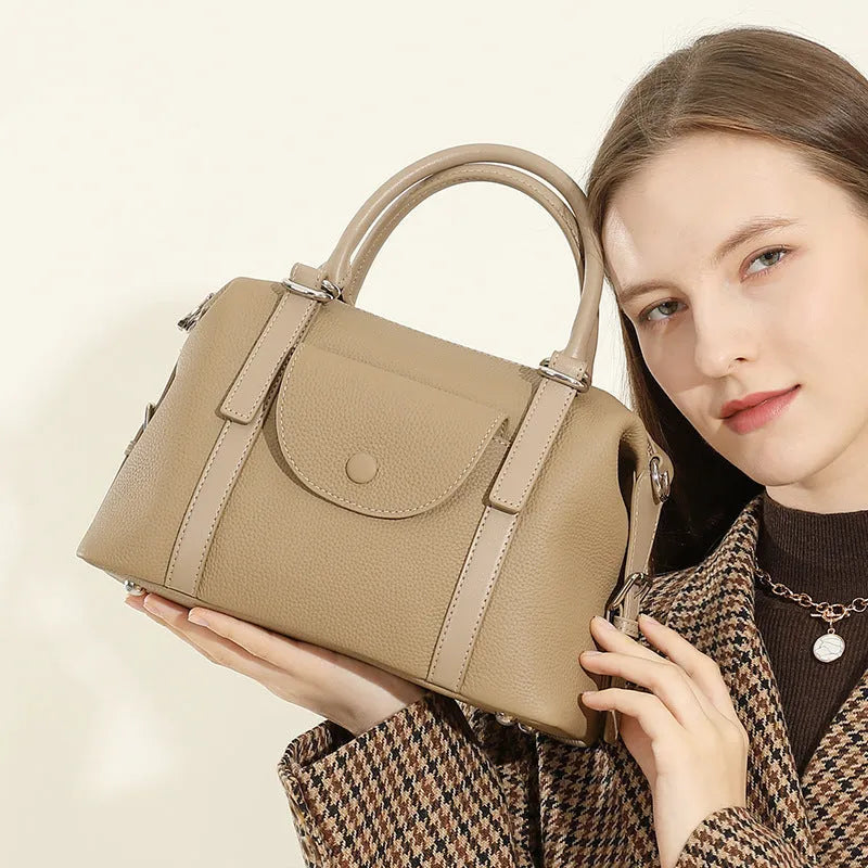 Genuine leather street trend handbag with lock detail and contrast stitching in 27x12x20 cm size