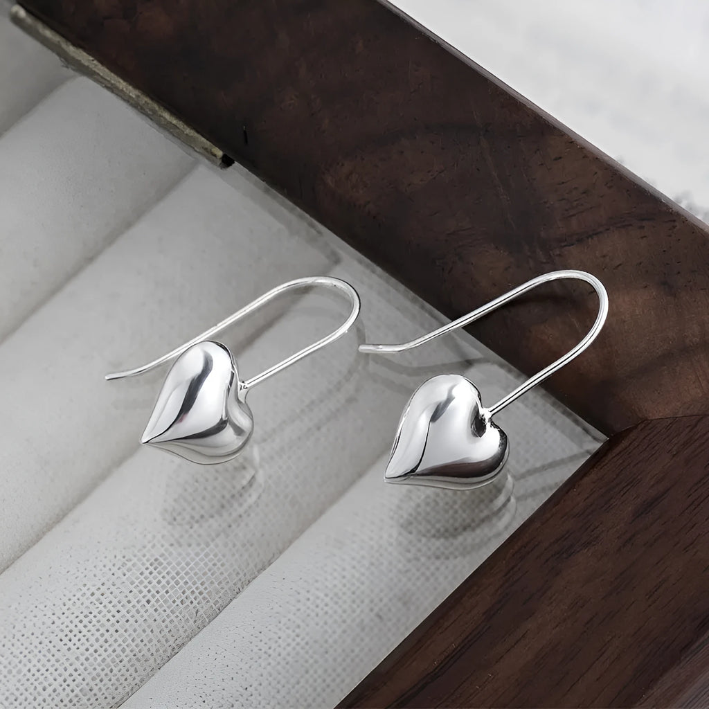 Silver-coloured heart-shaped earrings with three-dimensional design and glossy Korean style
