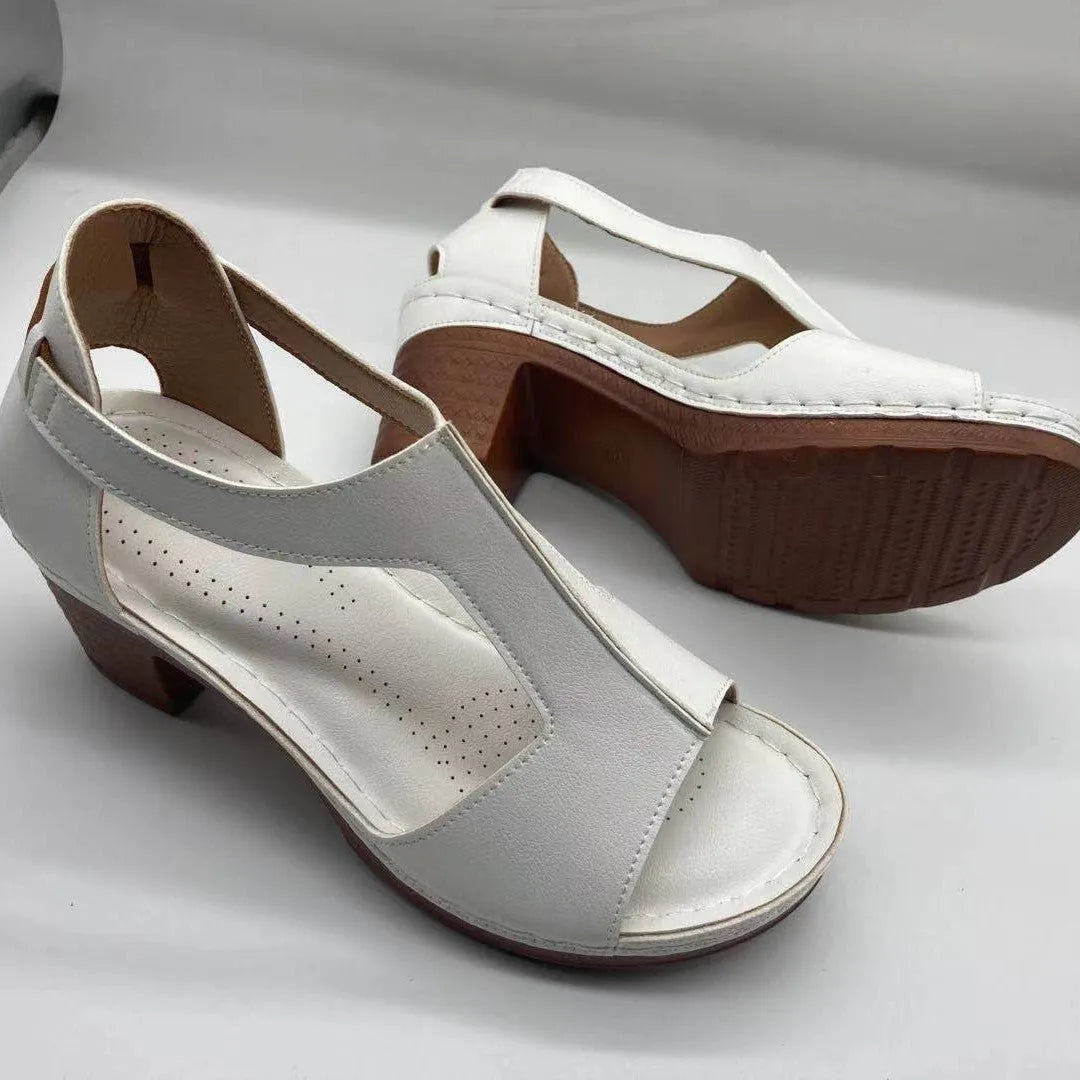 Women's white peep toe wedge sandals with a buckle strap on the ankle.