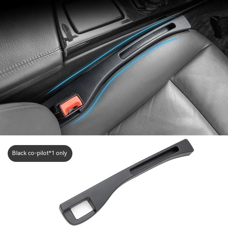 Black plastic car seat gap storage organiser box with handle inserted between car seat and centre console.