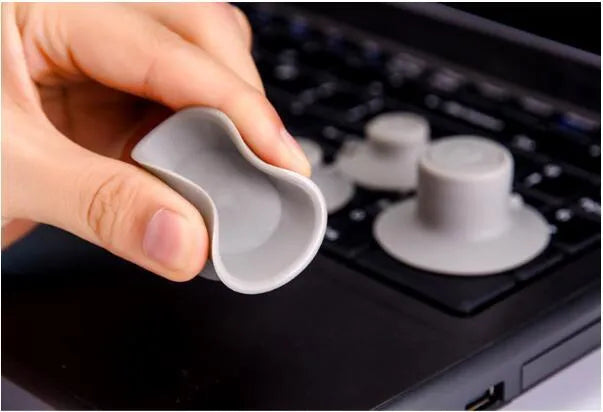 Set of four grey durable plastic laptop cooling pads: two large and two small, on a desk.