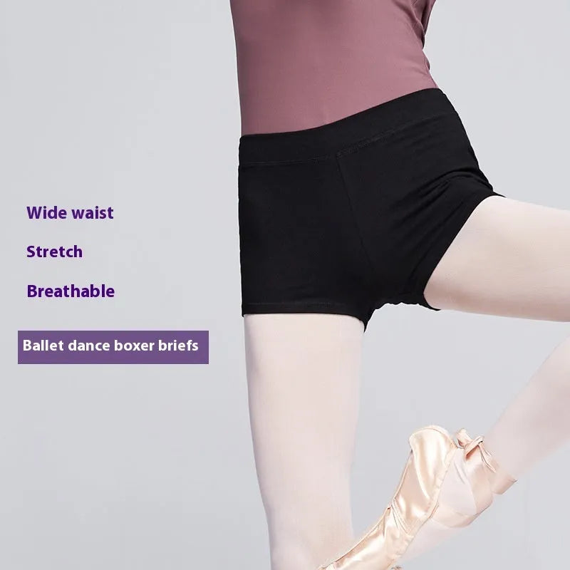 Black cotton dance shorts for women laid flat, showing solid colour and simple design for ballet practice.