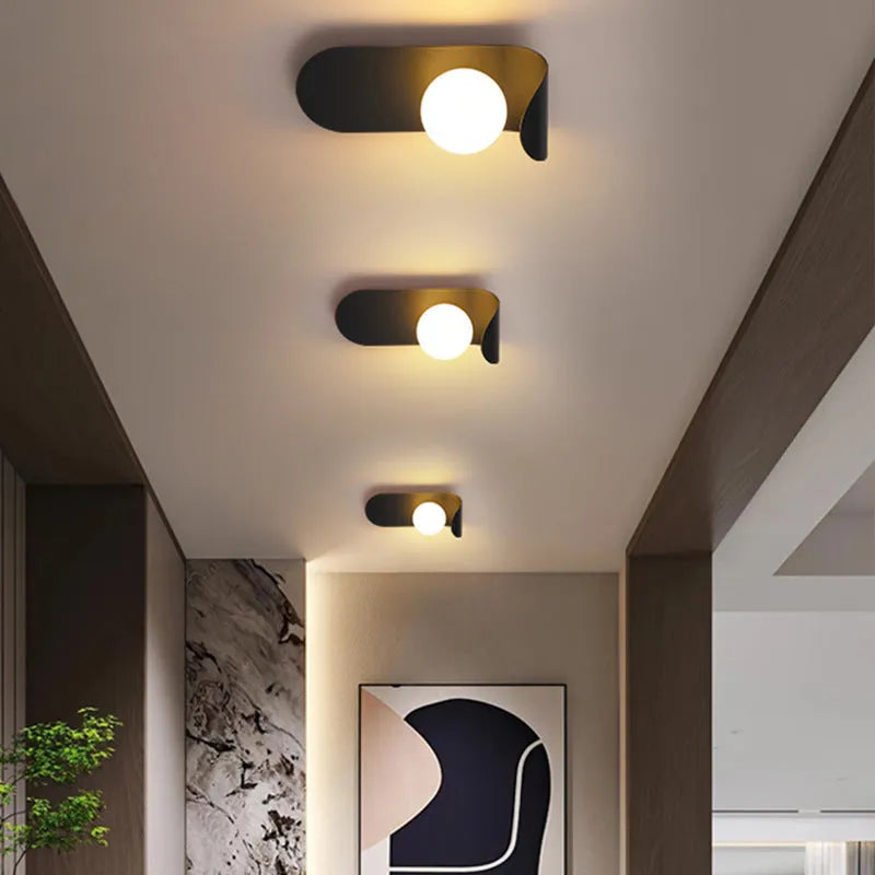 Modern minimalist black wall lamp with iron shade and LED light on a bedroom wall