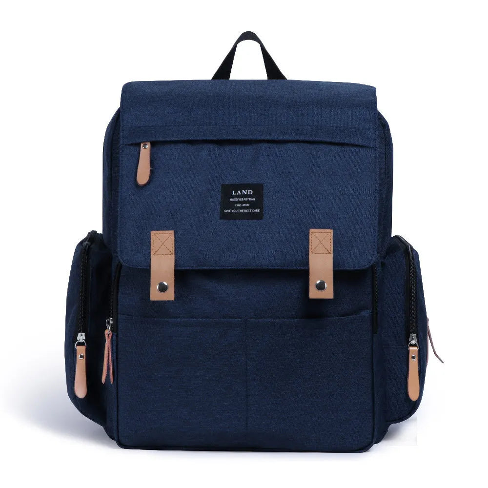 LAND Mommy large grey diaper backpack with multiple compartments and a changing mat laid out