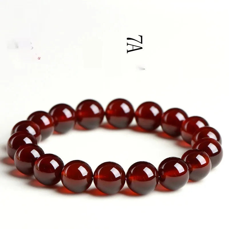 Close-up of an orange red garnet crystal bracelet with retro styling and Ruyi design details.