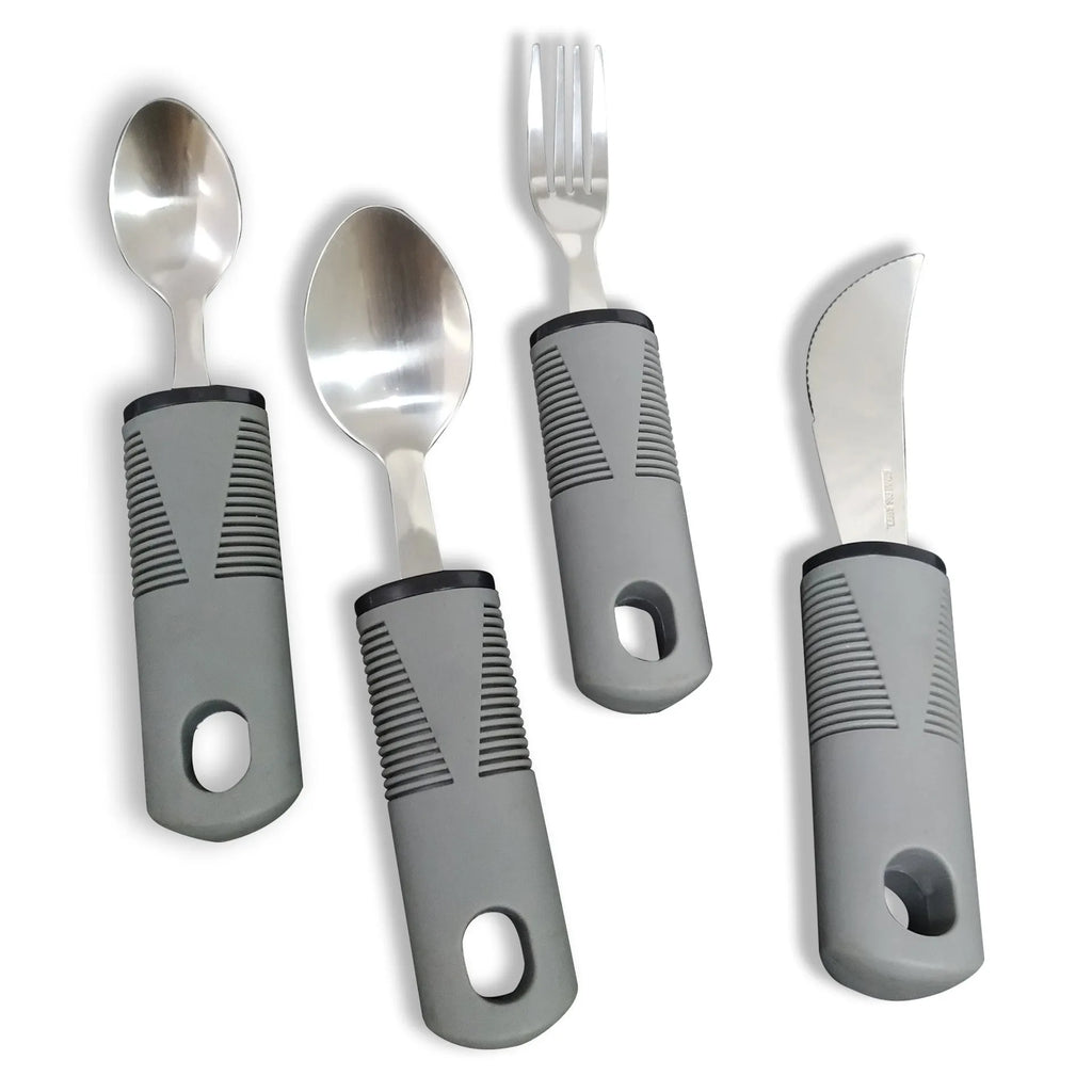 Stainless steel adaptive knife, fork, and spoon set with black rubber handles on a table.