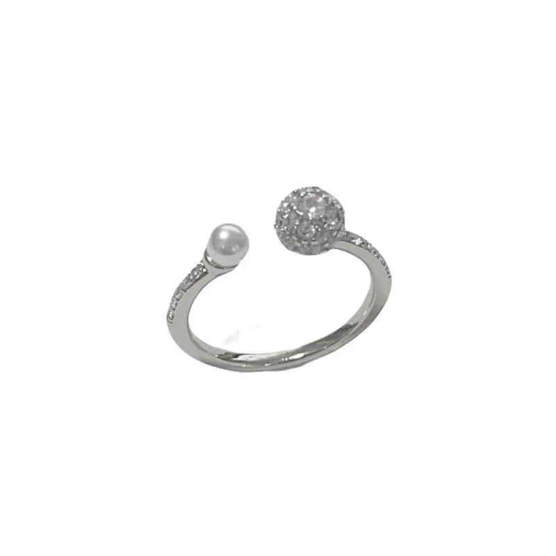 Golden open-end ring with a round zircon stone on a simple geometric band.