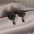 Pair of black rose zircon floral stud earrings with an 18K gold electroplated finish on copper.