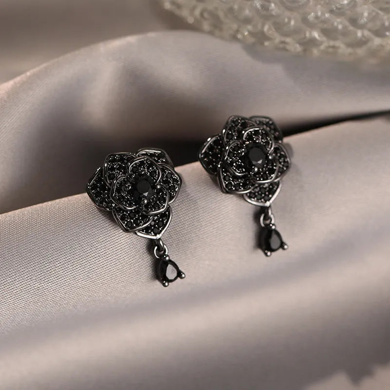 Pair of black rose zircon floral stud earrings with an 18K gold electroplated finish on copper.