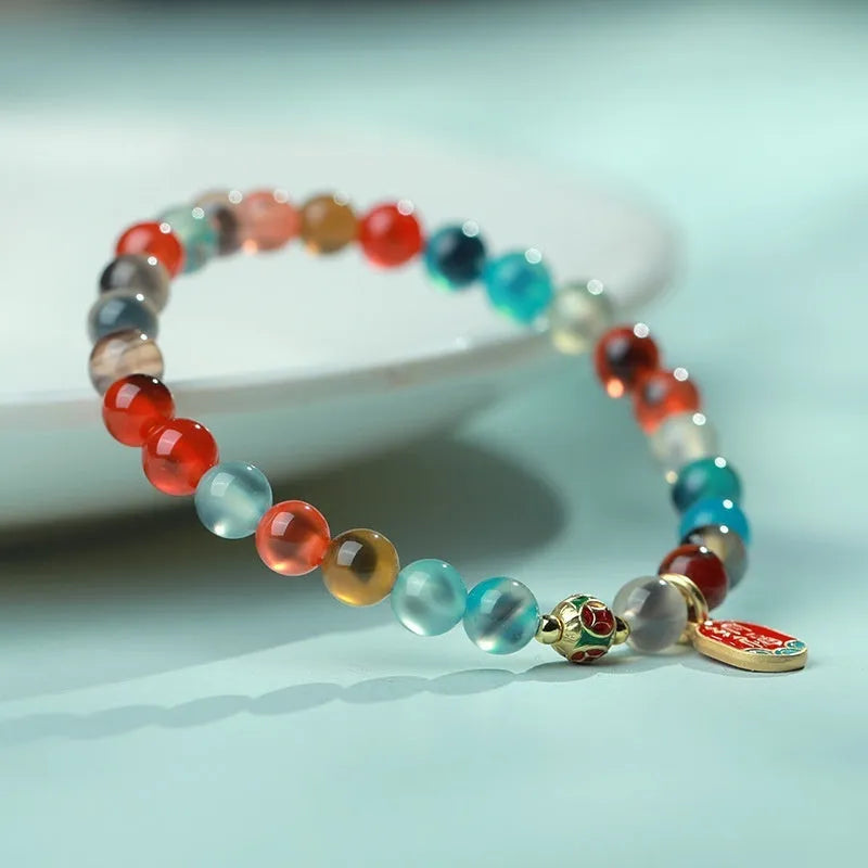 Handmade women's agate bracelet with coloured glaze copper coins in a snake chain, showing fu character or swallowing gold beast motifs.