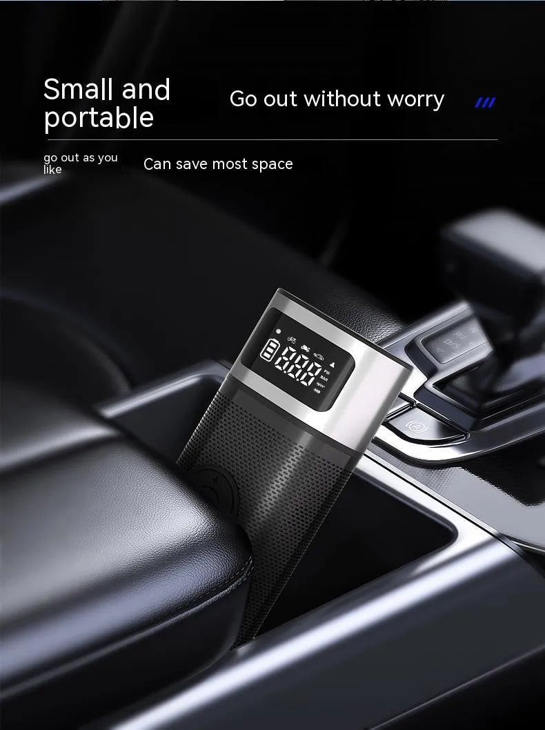 Black portable wireless car air pump with a digital display, inflation hose, and a set of nozzles on a black background.