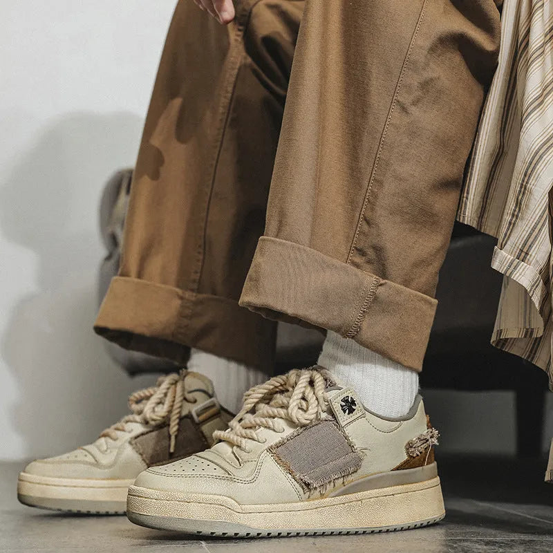 Beige low-top skateboard shoes with round toe and front lace-up closure on a flat rubber sole.