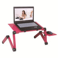 Red folding metal computer desk with cooling holes and mouse board on bed