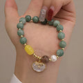 Green jade shell bracelet with adjustable silver chain on a wrist.