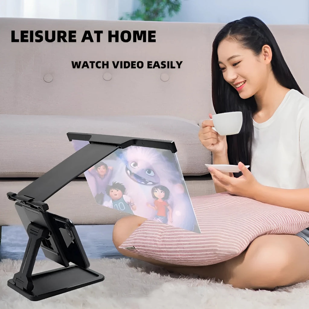 Black folding mobile phone screen magnifier with detachable holder on a desktop.