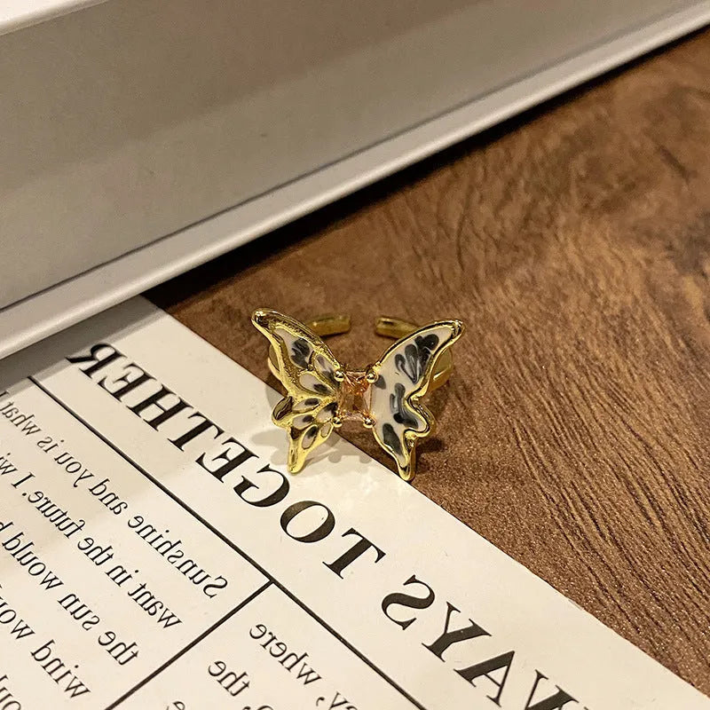 Copper butterfly women's ring with oil-drip finish showing open-loop design