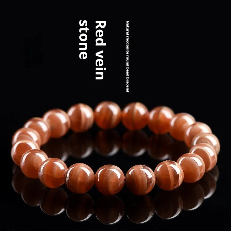 Natural old mine rhodochrosite round bead bracelet with geometric design and Ruyi elements.