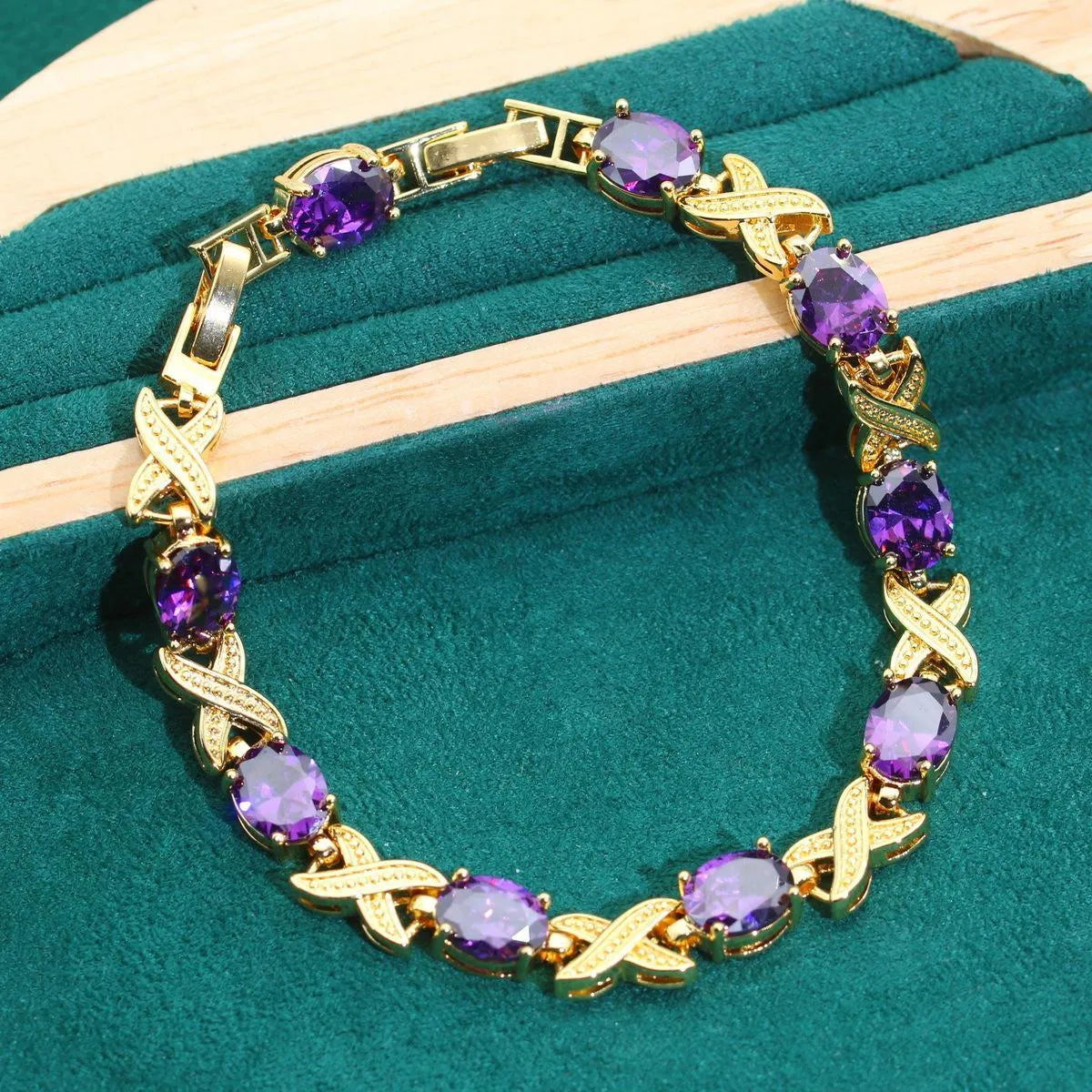 Gold-coloured jewellery set with coloured cubic zirconia stones, showing necklace, earrings, ring, and bracelet.