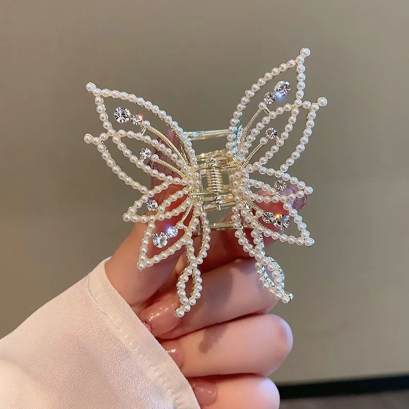 Butterfly-shaped hair clip with metal alloy construction and decorative rhinestone or pearl elements
