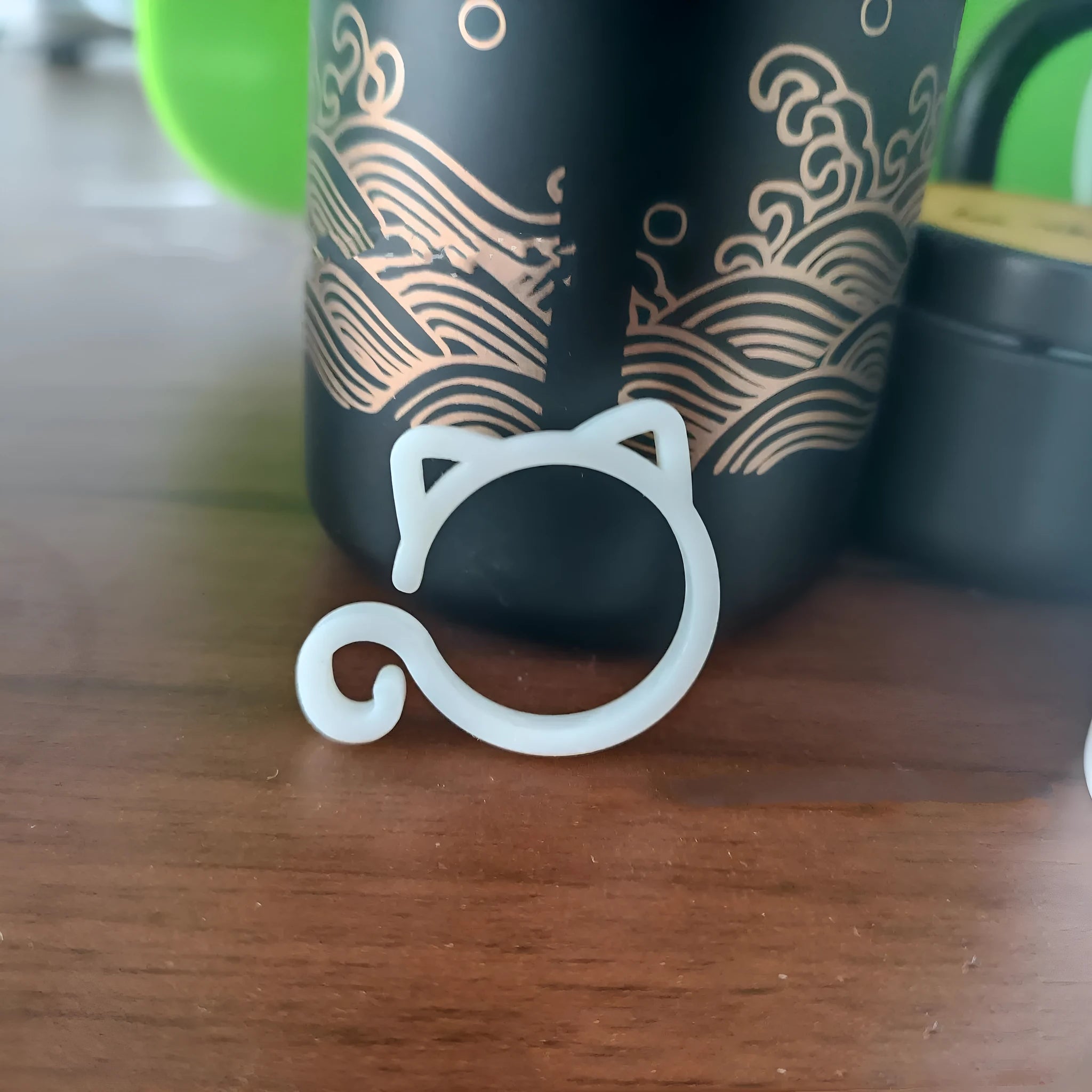 Decorative red plastic cat-shaped clip for gardening plant support.