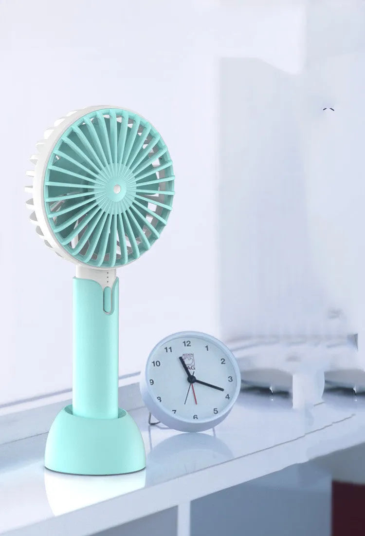Blue handheld USB fan with three-speed control and oscillating head on desktop