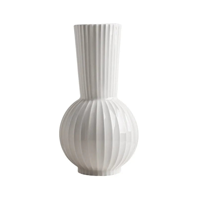 White ceramic ball vase with blue stripes on wooden table
