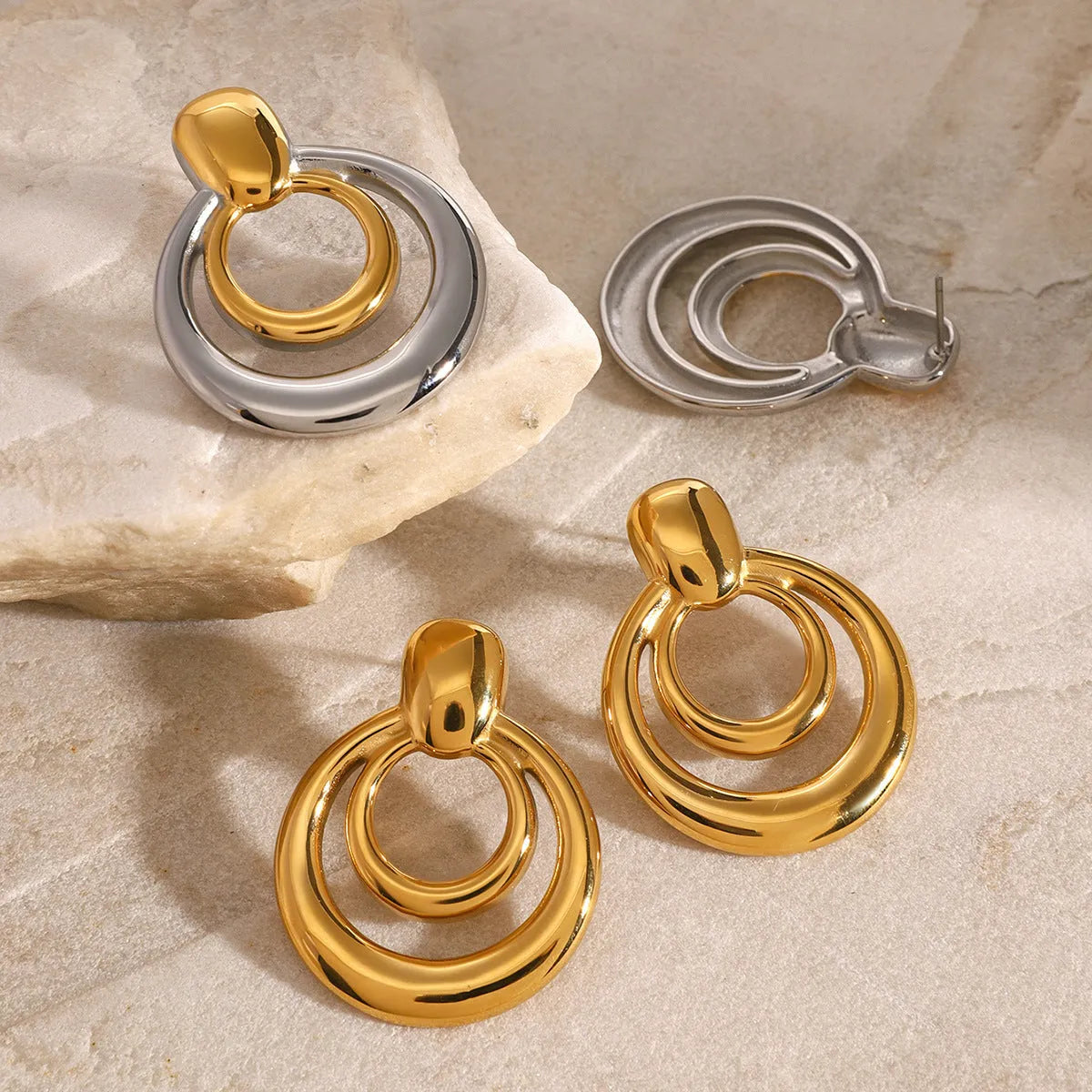 A pair of round gold-coloured geometric stud earrings with a double-layer hollow design.