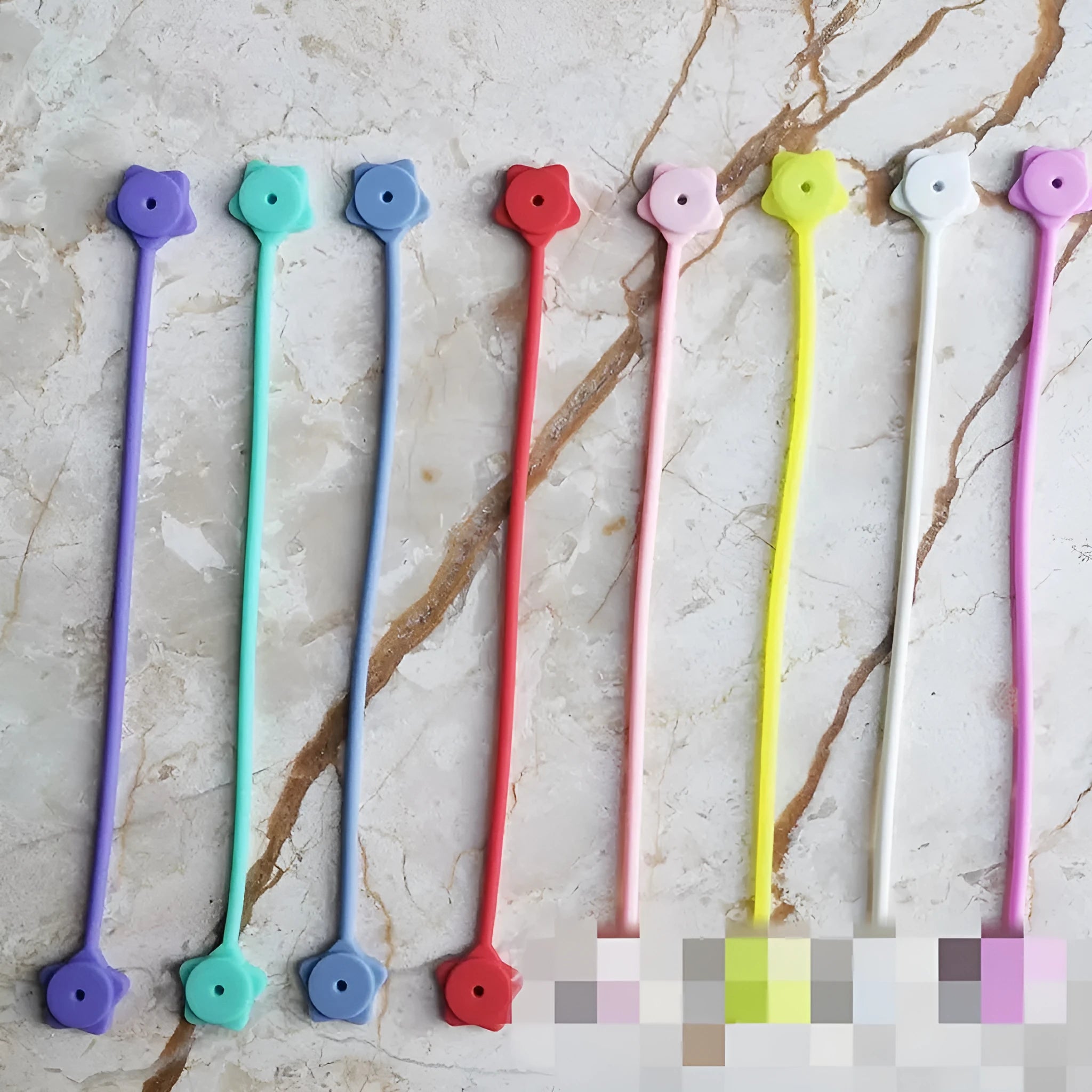 Small star-shaped silicone magnetic wire winder in various colours for organising headphone and computer cables.