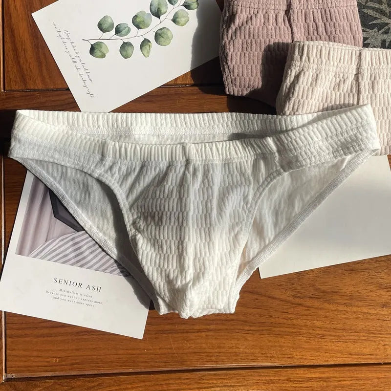Men's solid colour cotton triangle briefs in apricot, shown from the front on a mid-waist fit model.