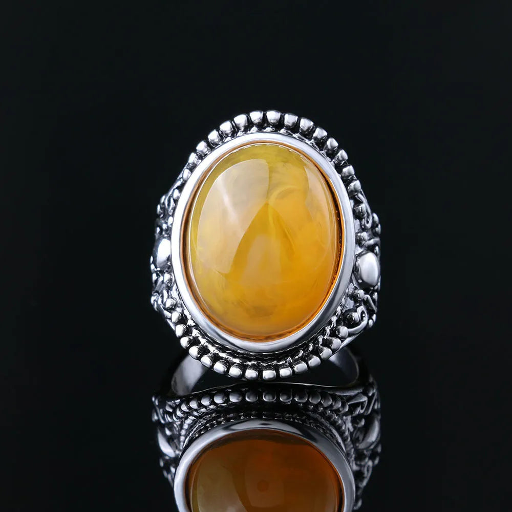 Geometric alloy ring with antique silver and amber electroplated finish shown on a hand.