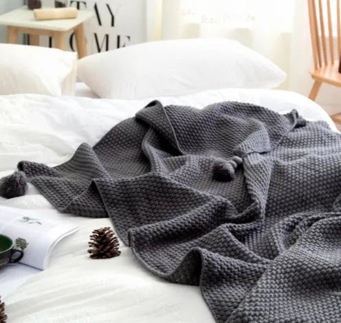 Nordic fringed knit ball acrylic blanket in beige colour on sofa