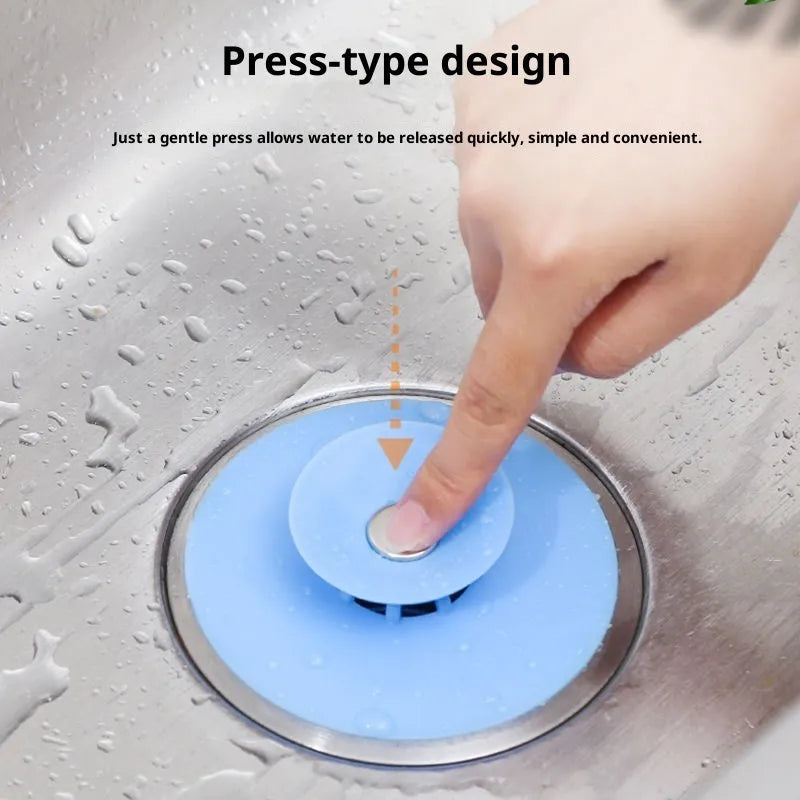 UFO-style silicone press sink drain cover in blue on a white basin, modern minimalist design