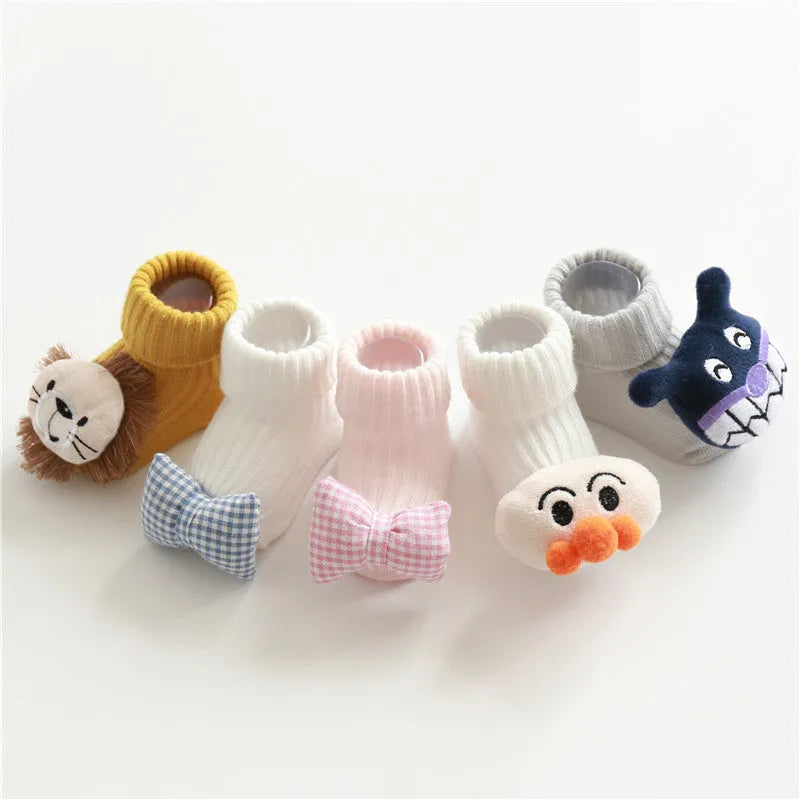 Cotton baby socks in multiple colours and prints including panda, lion, bows, and stars on a white background.