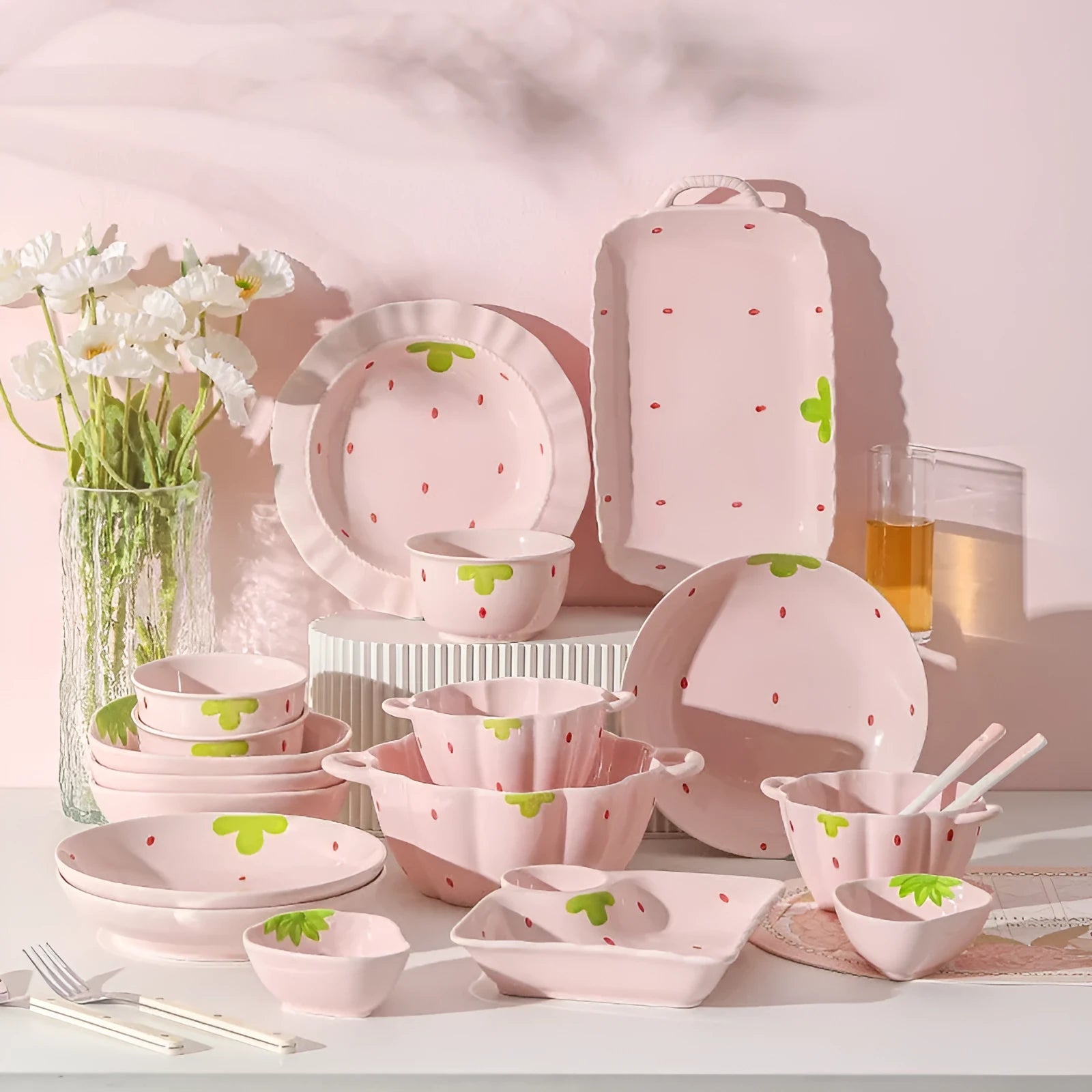 Cute strawberry pattern porcelain dinnerware set showing bowl, plate, and twist spoon on a table.