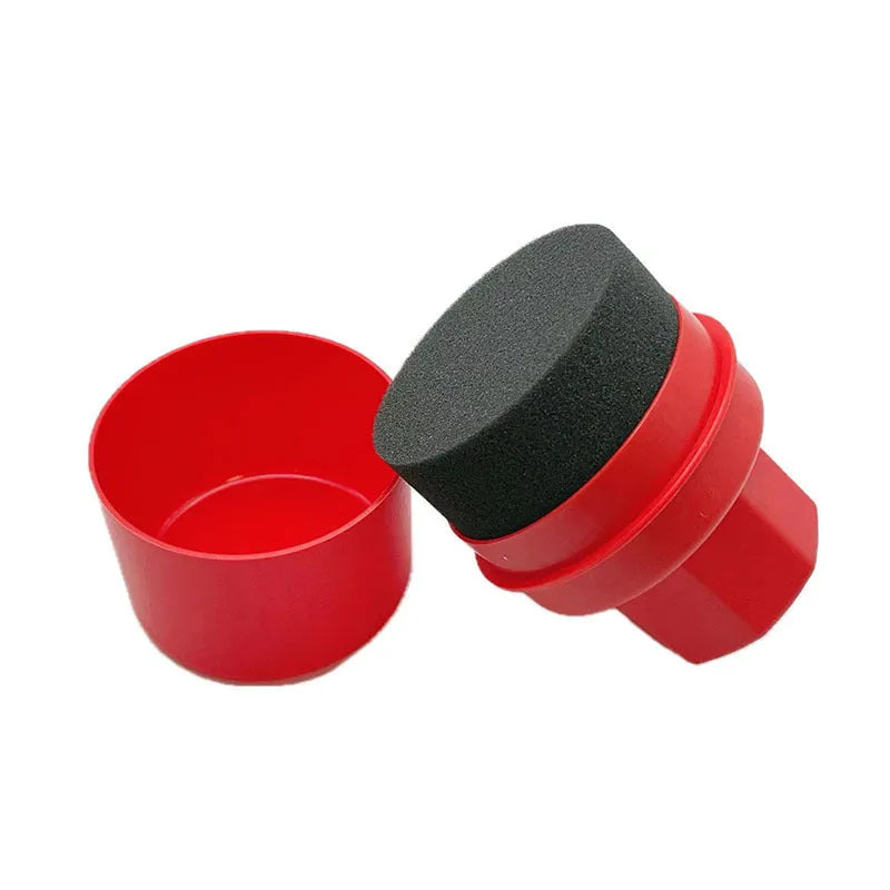 Black and red car tyre polishing sponge brushes with lids on a tyre sidewall