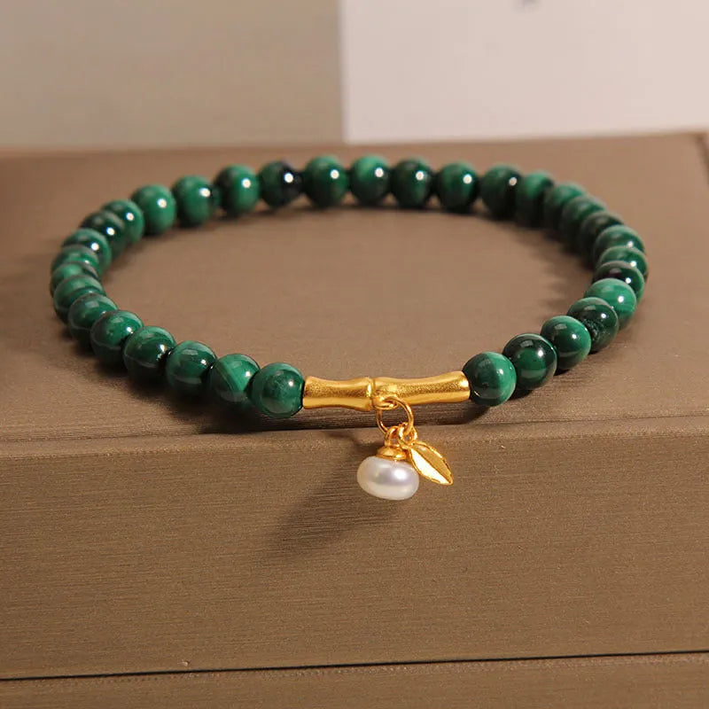A women's adjustable bracelet made of white crystal with a lucky bamboo charm on the wrist.