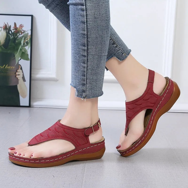 Women's wedge heel flip flop sandals in black with an adjustable buckle strap on the back.